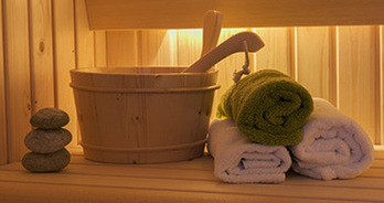 Stenen met een emmer en handdoeken in een sauna