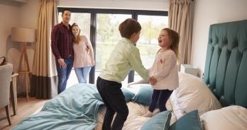 Kinderen springen op bed in een hotelkamer