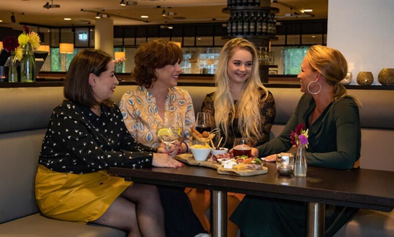 vriendinnen die het gezellig hebben met eten op tafel 