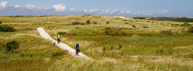 672 x 250 Mensen fietsen door duinen Ameland