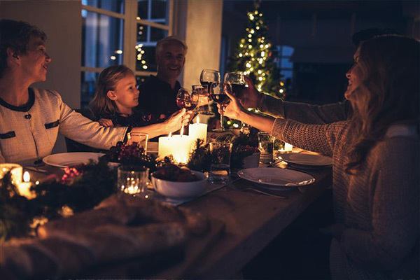 Vrienden gezellig aan kersttafel.