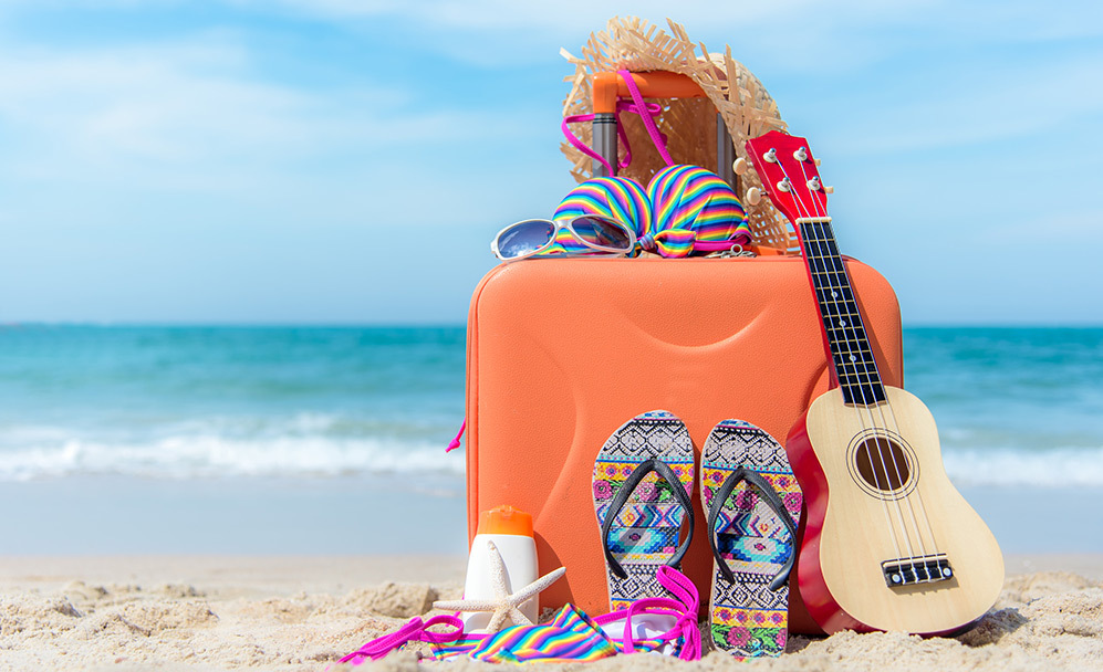 Koffer met zwemspullen op het strand
