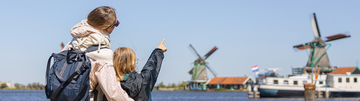 Moeder en dochter bekijken molens aan het water